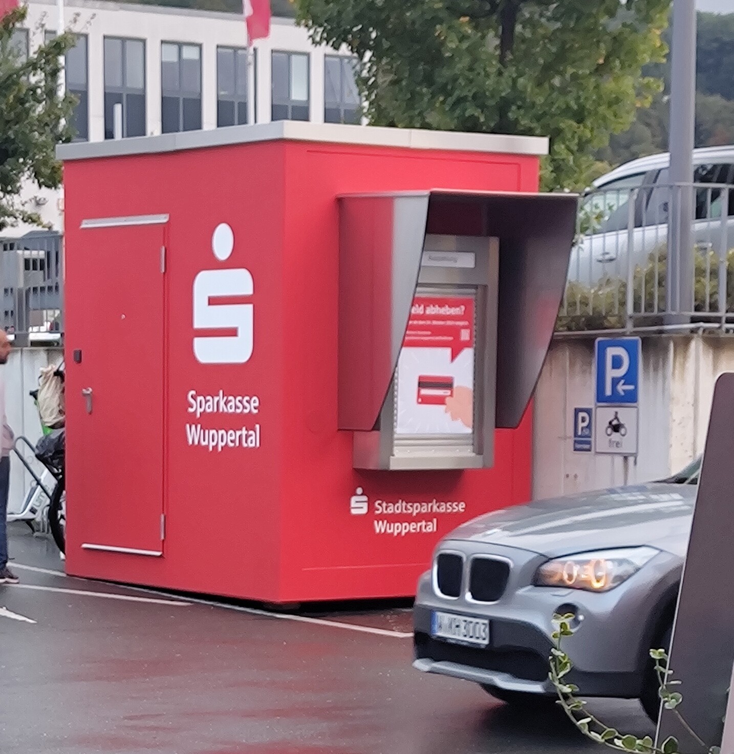 Roter Container mit Geldautomaten auf dem Rad-Parkplatz 