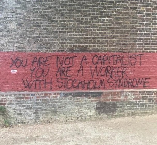 Grafitti saying You Are Not A Capitalist, You Are A Worker with Stockholm Syndrom