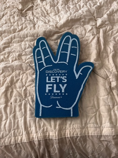 A foam finger/hand in the style of a Vulcan salute. On it, it says “Star Trek: Discovery | Let’s Fly”.